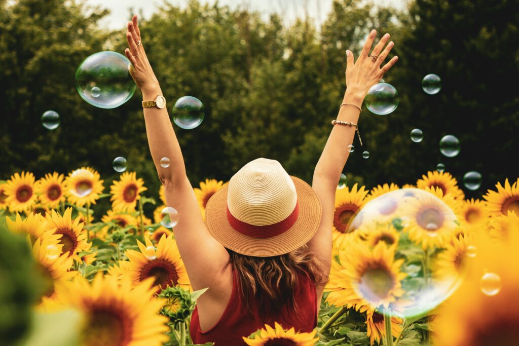 pexels photo 1263986 1263986 A joyful woman in a sunflower field with bubbles, expressing happiness on a summer day.